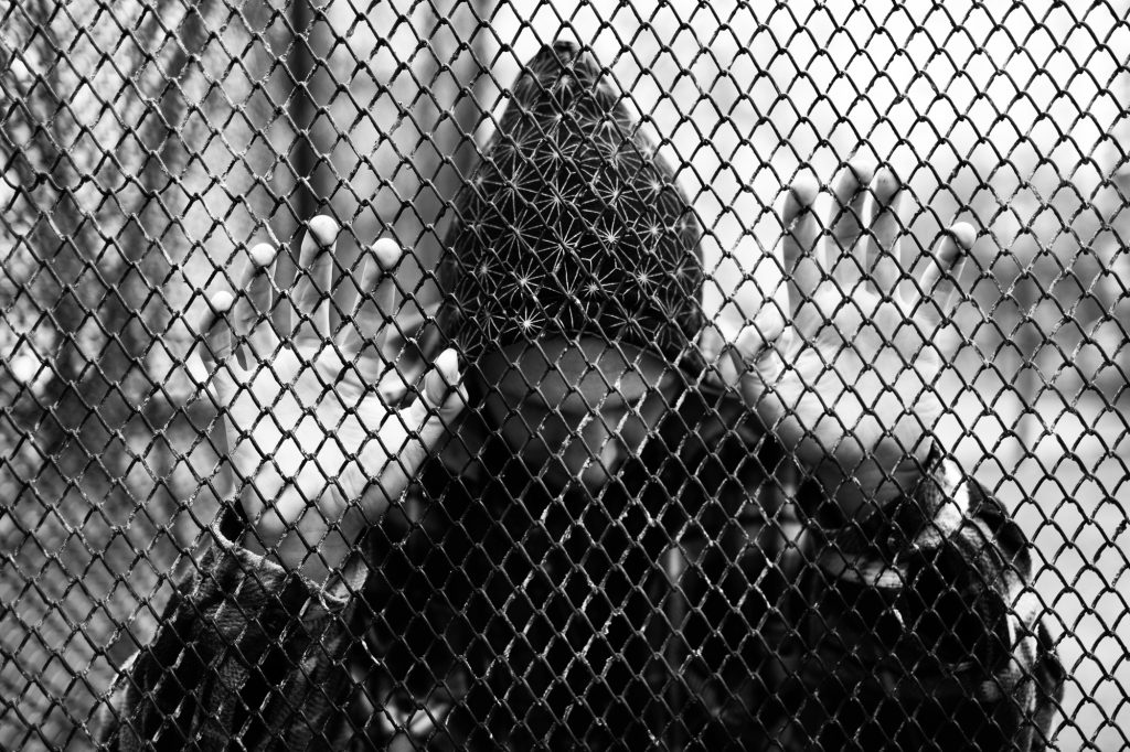 portrait of a sad lonely teenager, young guy in a black hoodie in an abandoned place