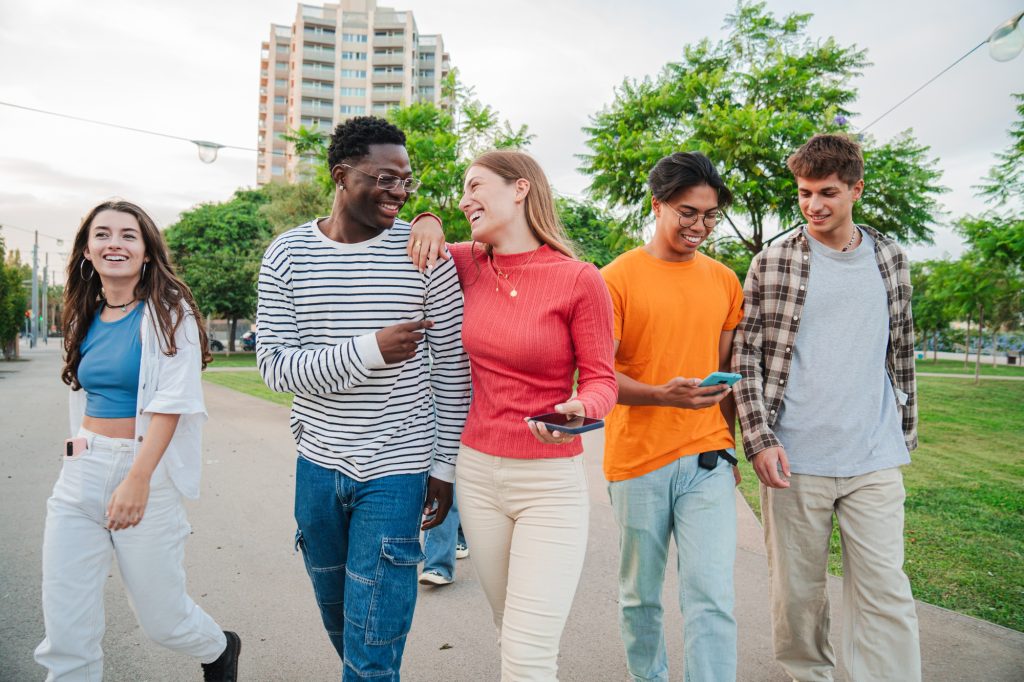 Youthful Conversations on a meeting: Big group of joyful friends walking and chatting together on